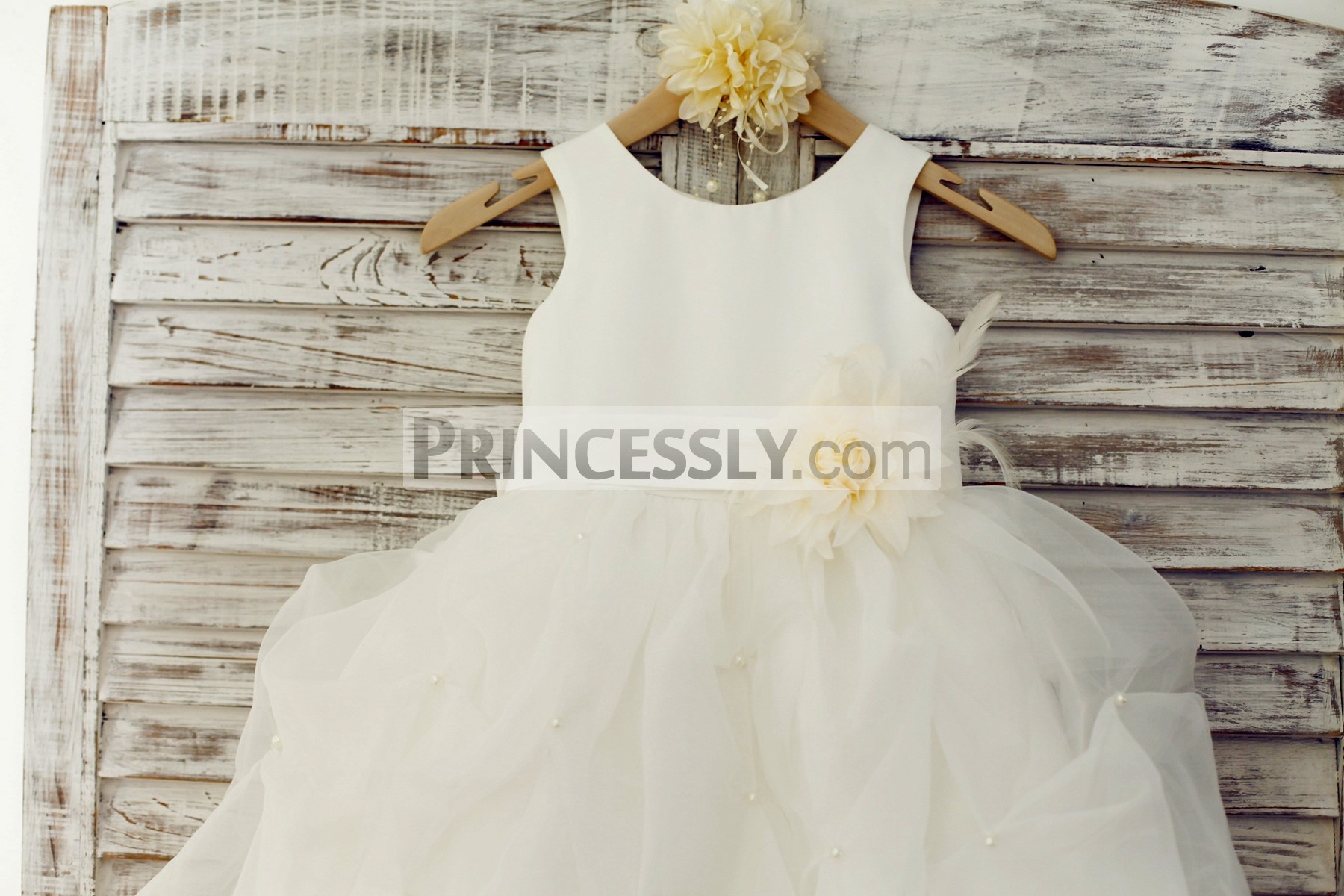 Scoop neckline and sleeveless bodice with belt and feather flower