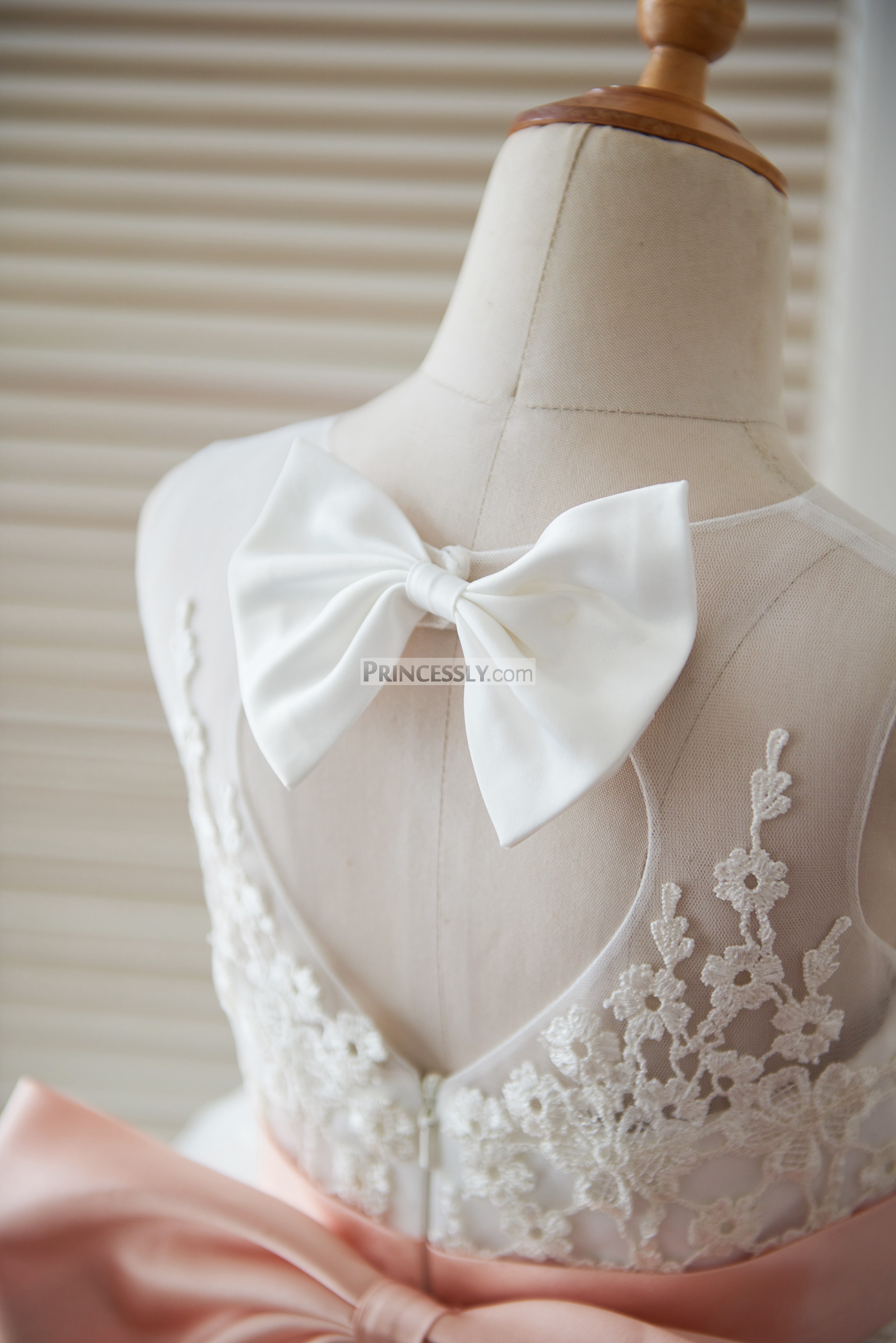 A tiny ivory bow on the top of bodice