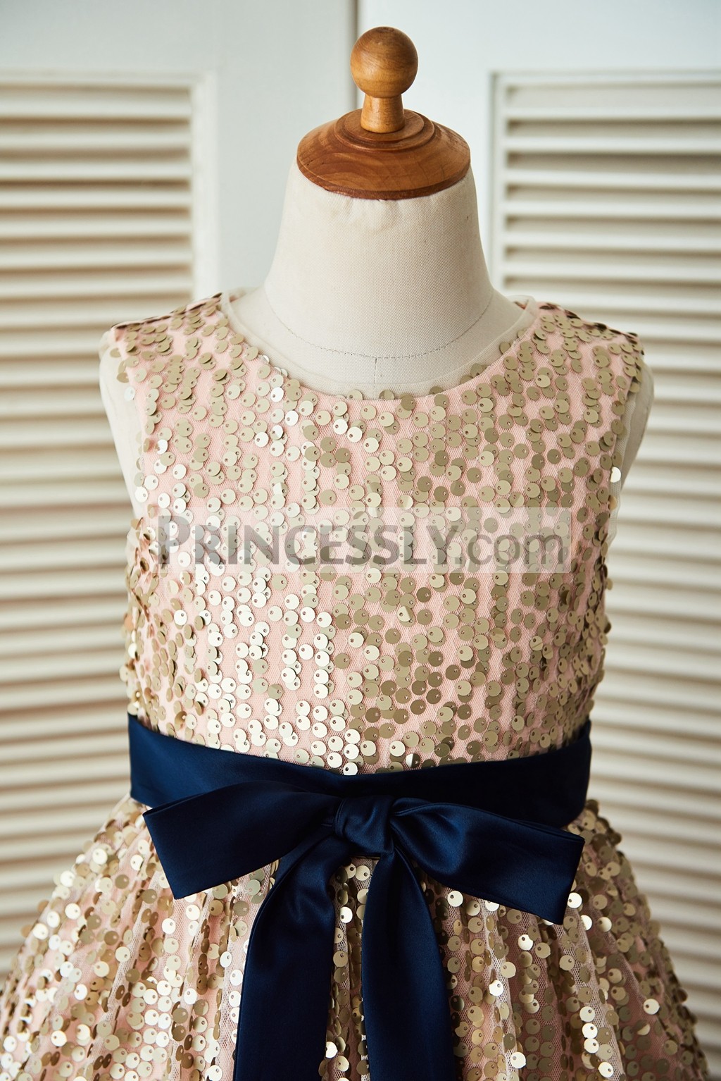 Champagne gold sequin sleeveless bodice with navy blue belt