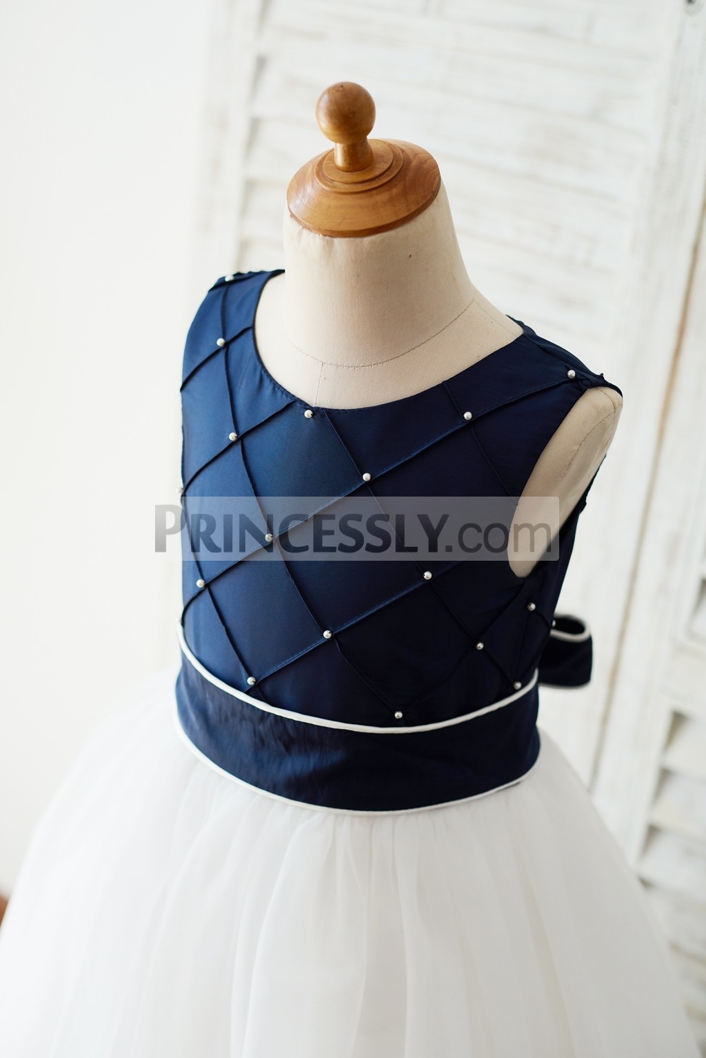 Detachable navy blue sash with ivory edge tied at back